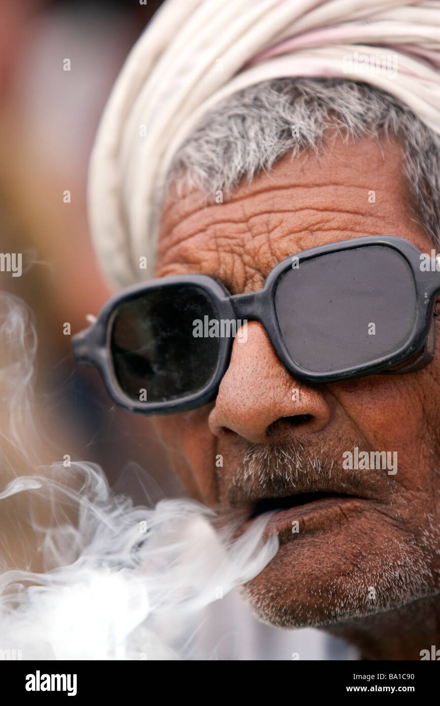 An Indian man smokes a Bidi cigarette at a political rally for BSP candidate Kumari Mayawati at Palwal Haryana State India Stock Photo