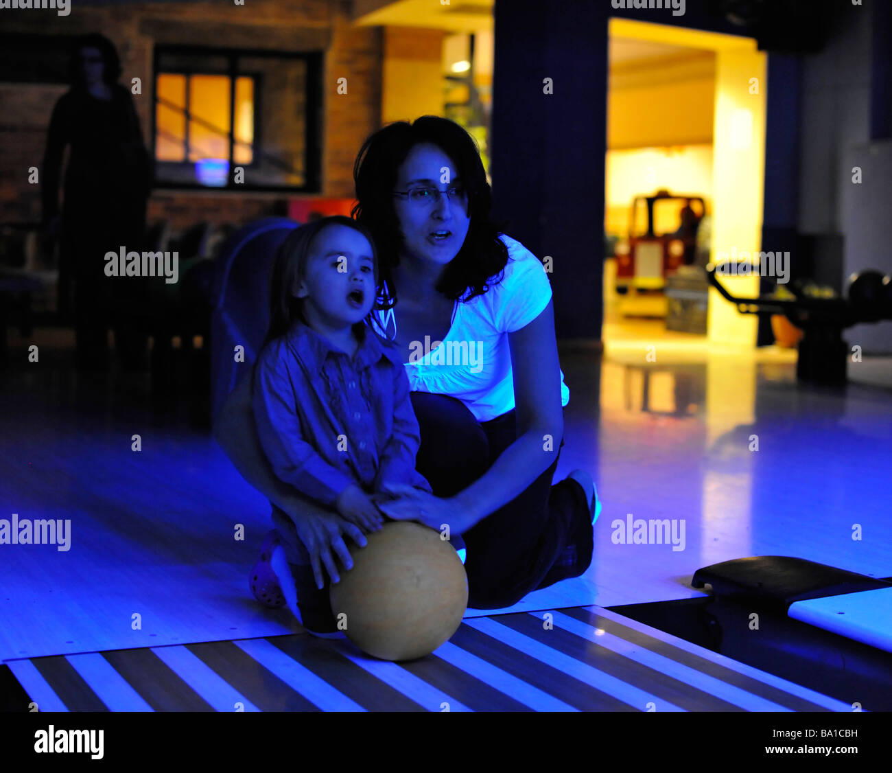 Mother and Daughter with bowling ball with blue lighting MR Stock Photo