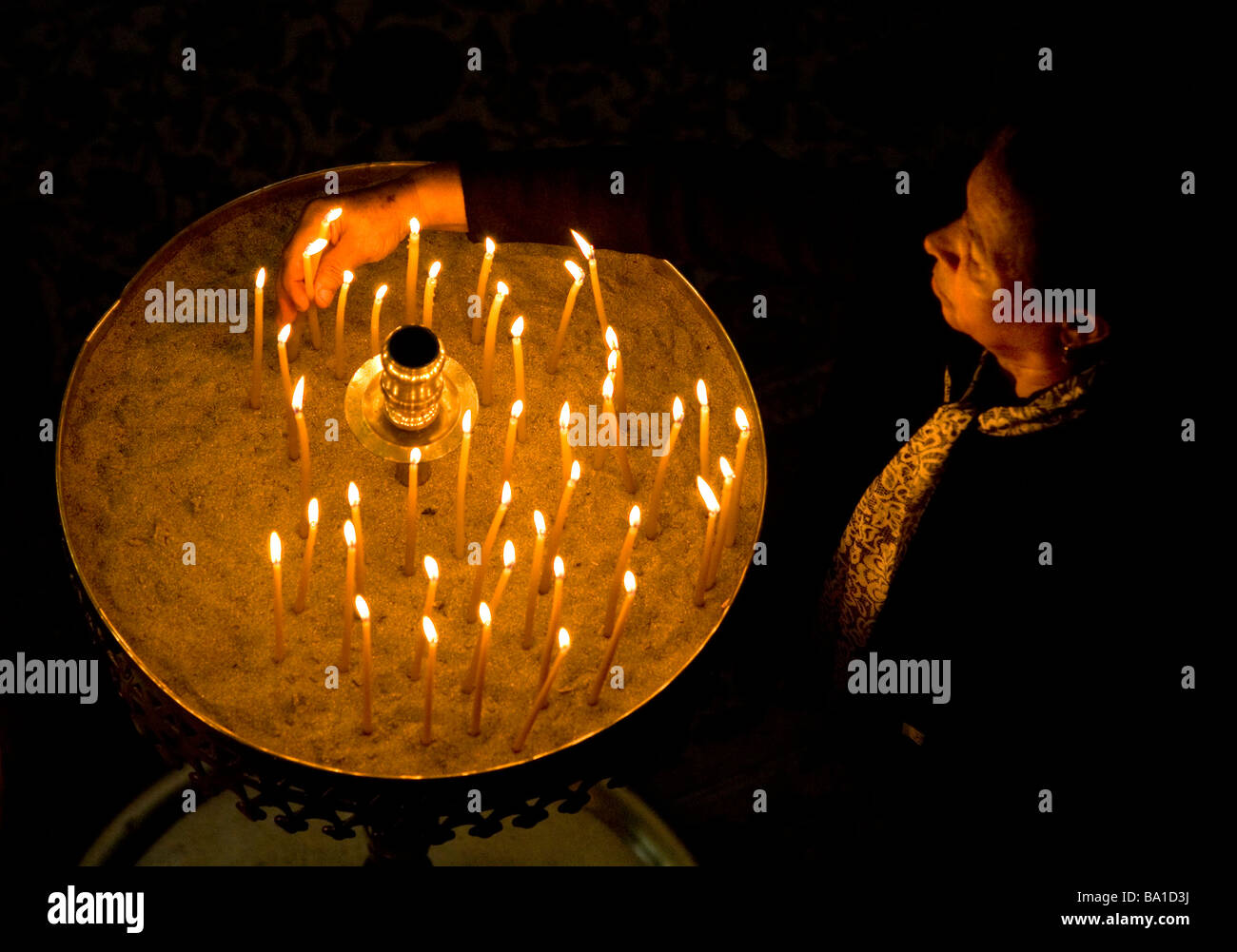 woman lighting a candle in an orthodox church. Parikia, Paros island