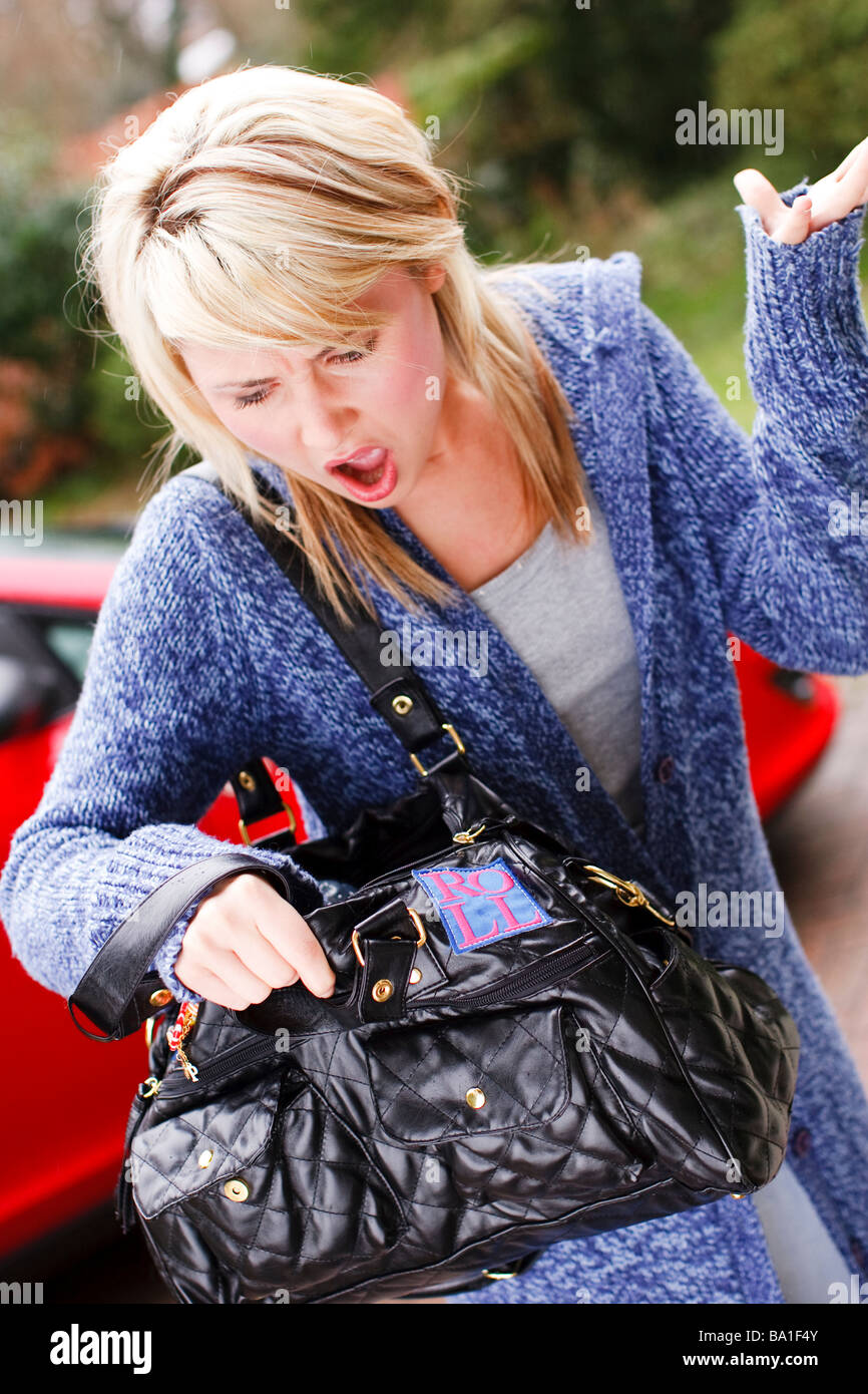 woman searching in her bag for her purse or mobile phone Stock Photo