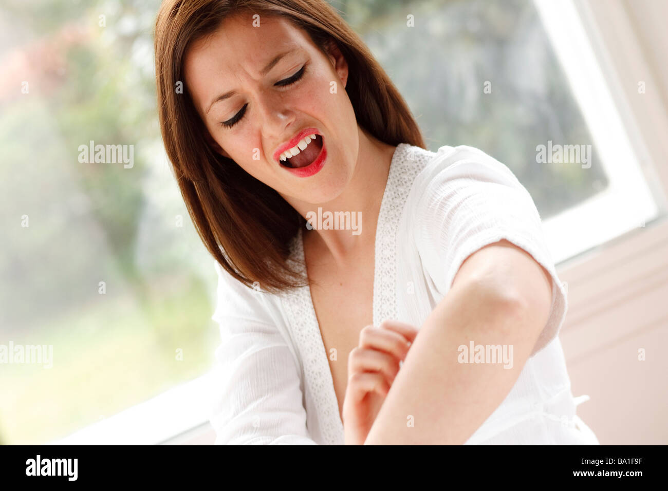 woman scratching her arm Stock Photo