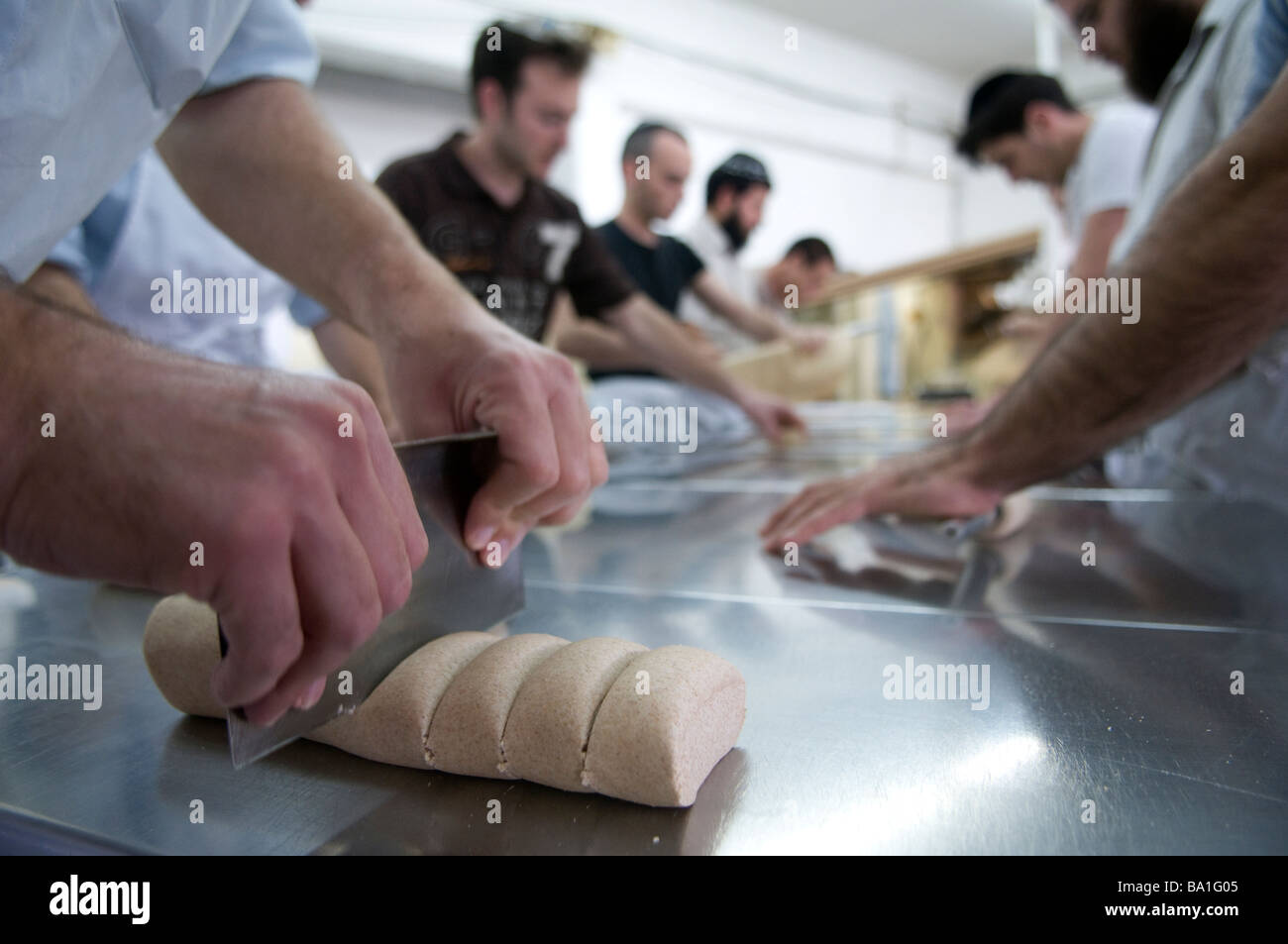 Orthodox Jews kneading Matzo dough in a bakery for traditional handmade Passover unleavened Matzo bread at Kfar Chabad bakery in Central Israel Stock Photo