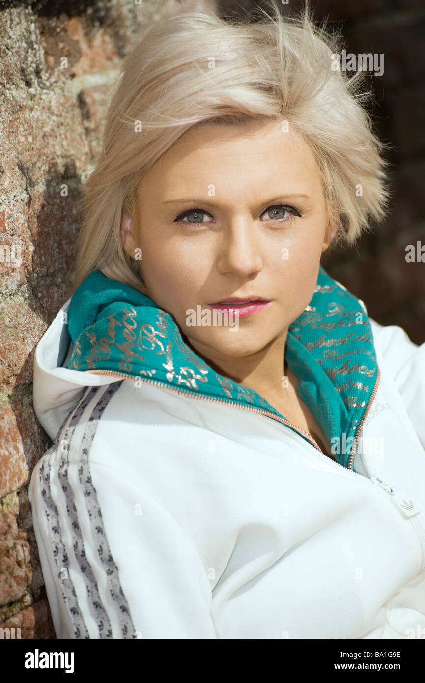 Pretty young blonde girl wearing a white adidas top Stock Photo - Alamy