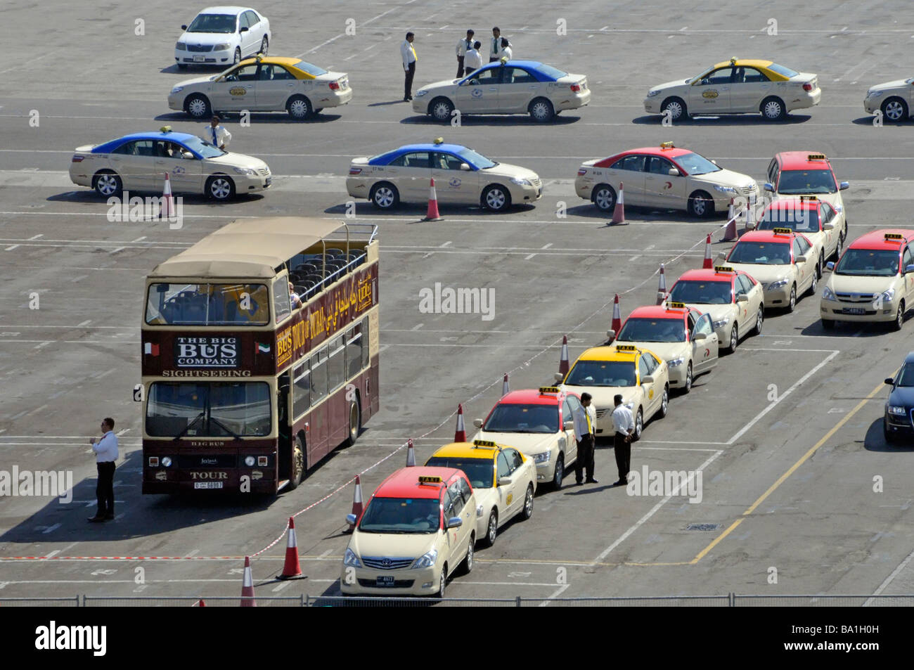 Dubai Port Rashid dockside queue of taxis waiting to collect holidaymakers from cruise liner includes Big Brown tour bus Stock Photo