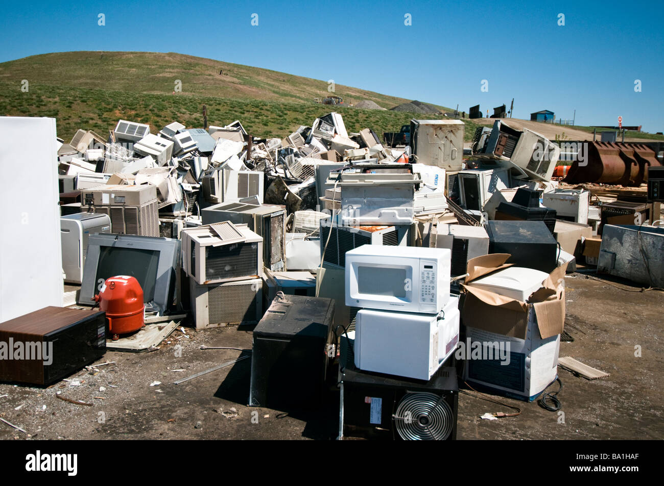 Microwave ovens and air conditioners stacked and ready for recycling at the Prince William County landfill / dump, Virginia USA Stock Photo
