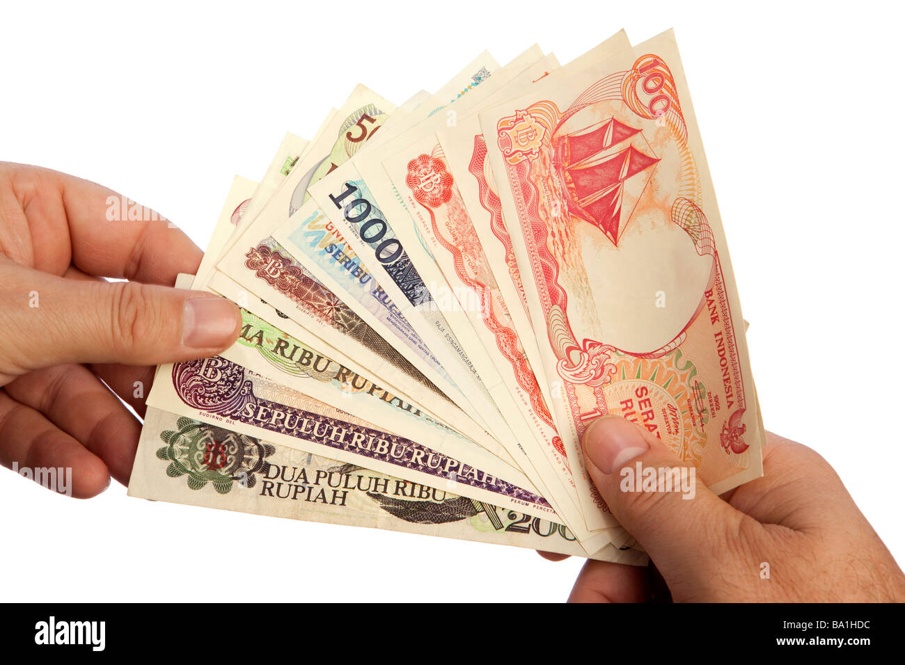 Money male hand holding handful of Indonesian currency Stock Photo