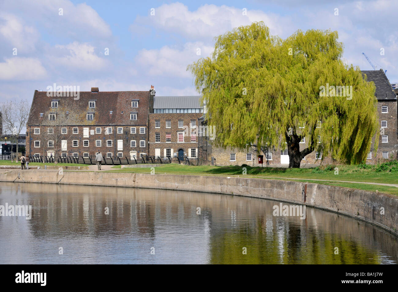 Part of the canalised River Lea Navigation waterway at historical Grade I listed buildings on Three Mills watermill site Bromley By Bow East London UK Stock Photo