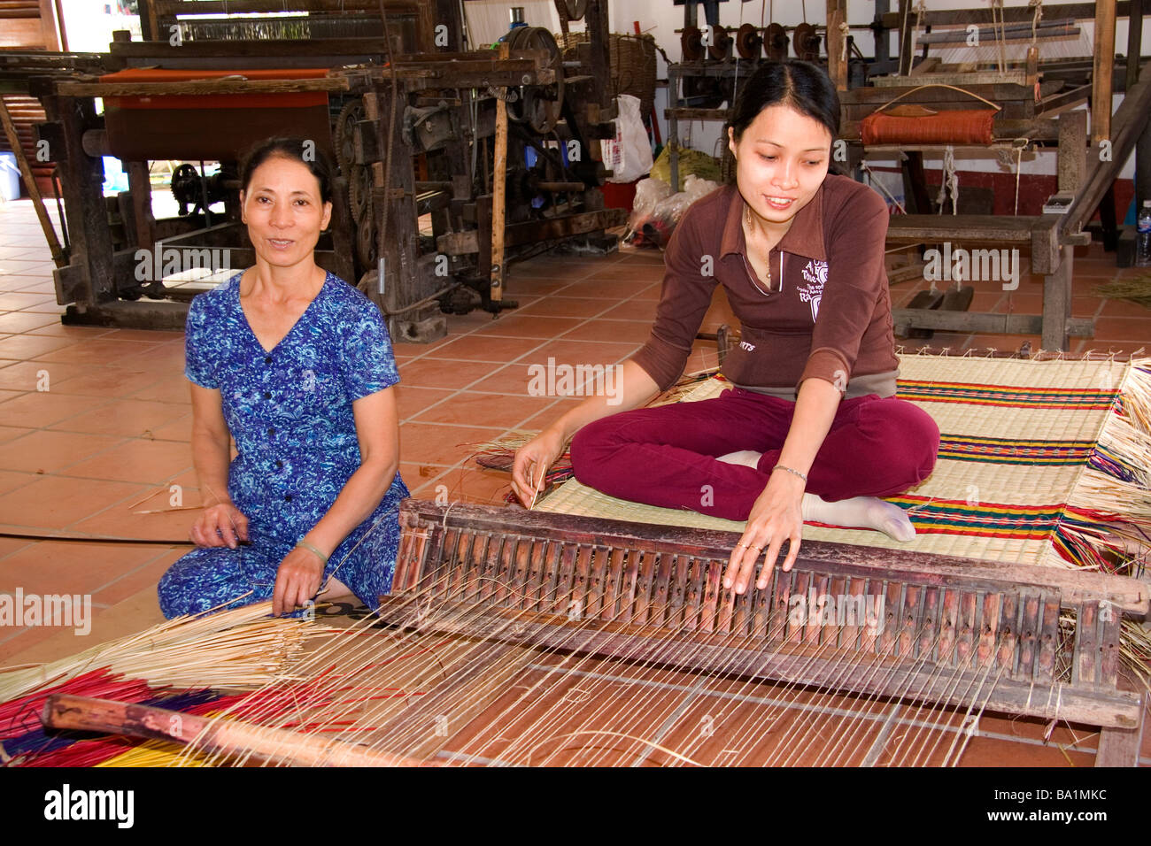 Vietnamese women weaving mats at a craft factory in Hoi An Vietnam