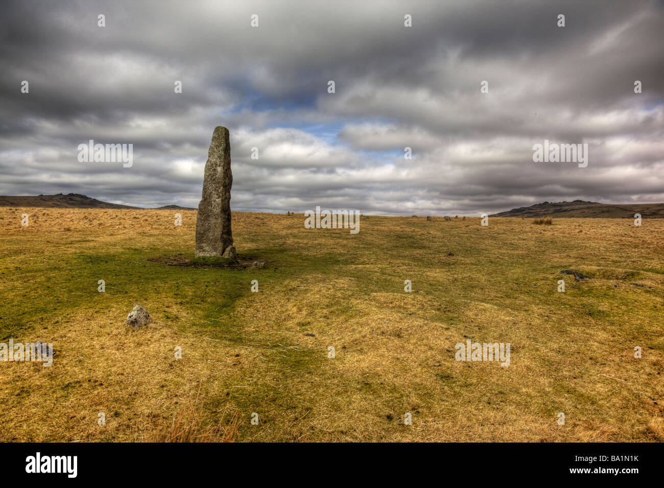 Standing stone above Merrivale on Dartmoor with Great Staple Tor and Great Mis Tor in the background Stock Photo