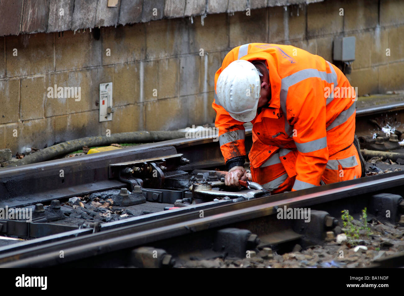 Railway worker repairing points on a railway line, Britain, UK Stock Photo