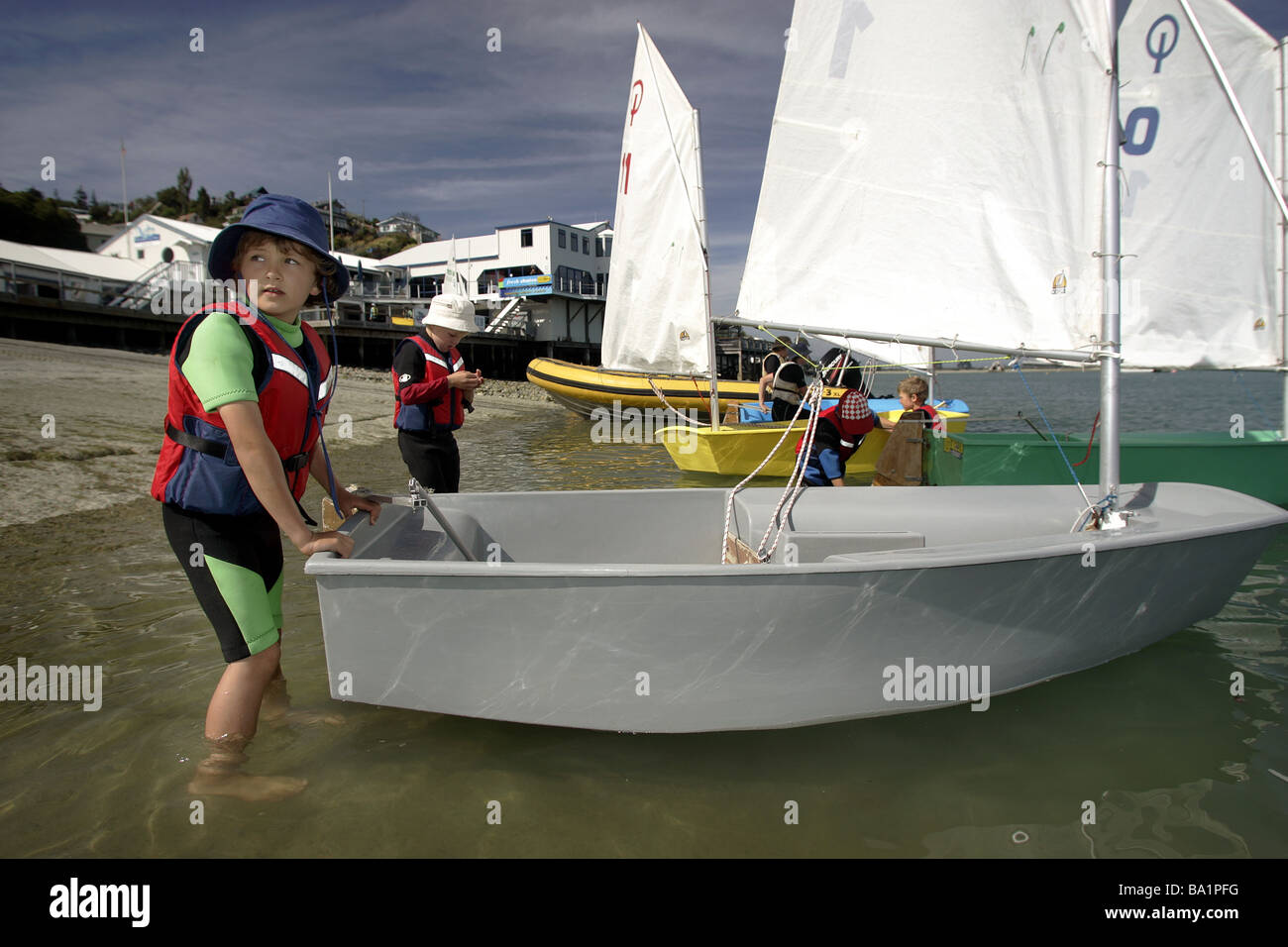 young sailors launching optimist dinghys at Nelson Yacht Club, New Zealand Stock Photo