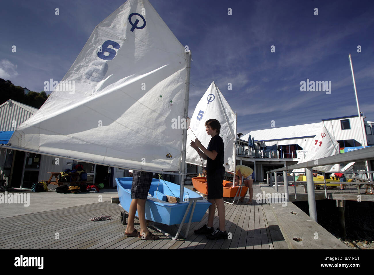 young sailors getting ready to launch an optimist dinghy at Nelson Yacht Club, New Zealand Stock Photo