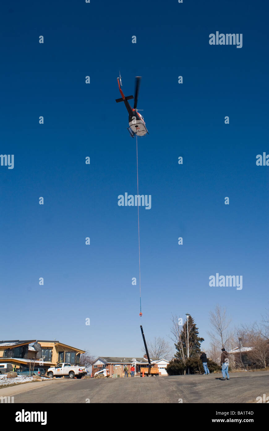 A helicopter is used to place a new utility pole Stock Photo
