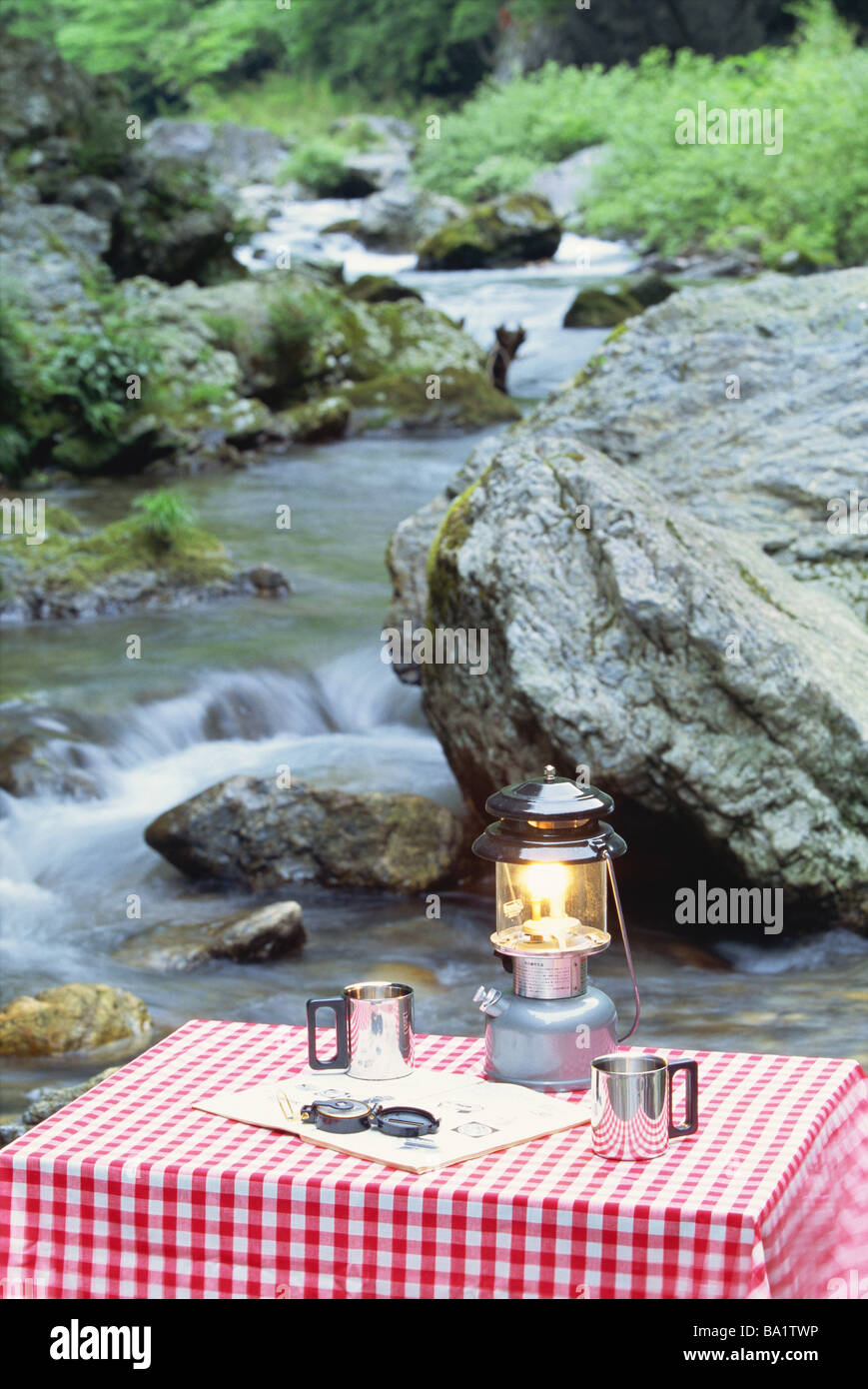 Table with Coffee Mugs Near Riverbed Stock Photo - Alamy