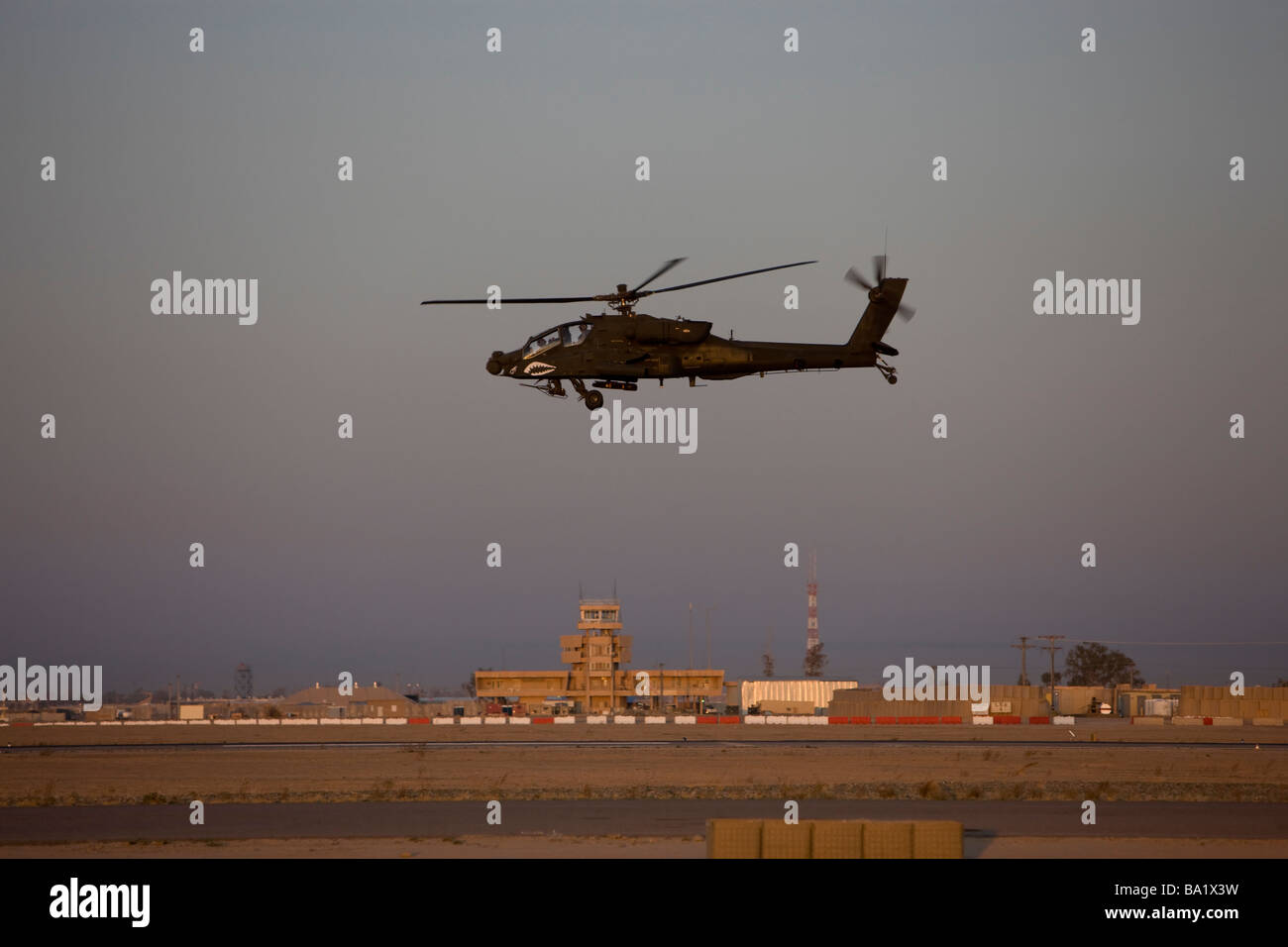 Tikrit, Iraq - An AH-64 Apache helicopter flies by the control tower on Camp Speicher. Stock Photo