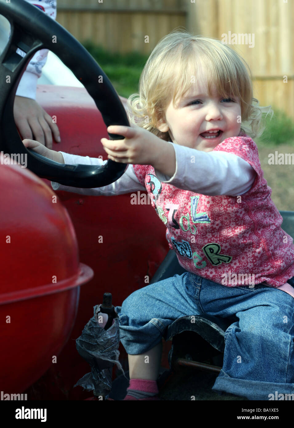 Toddler girl on tractor Stock Photo Alamy