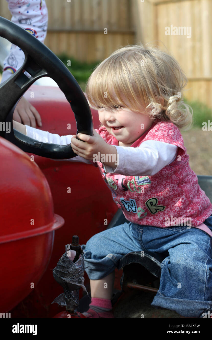 Toddler girl on tractor Stock Photo Alamy