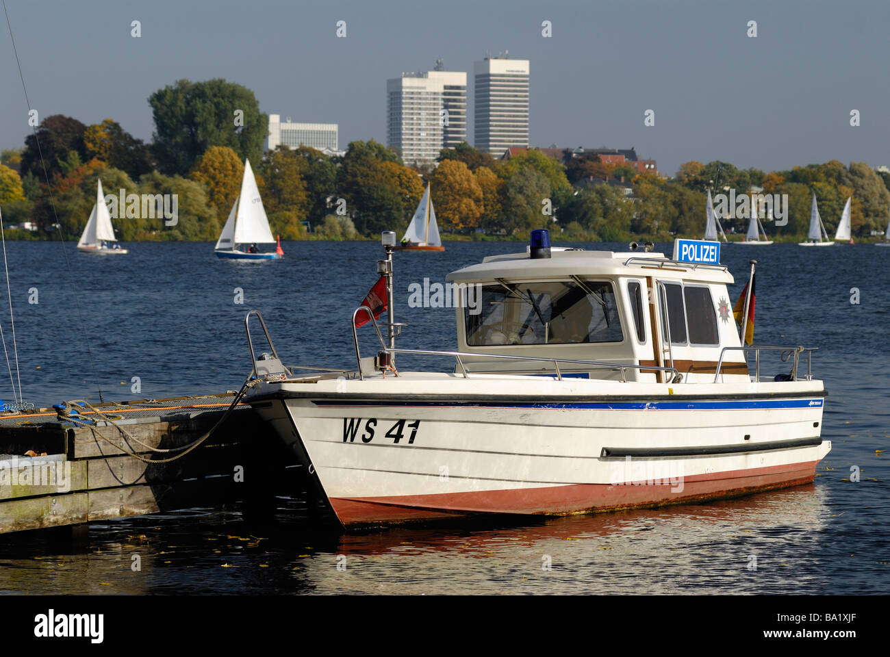 A small Police boat upon the Außenalster, in the background the skyskrapers of Mundsburg in Hamburg, Germany. Stock Photo