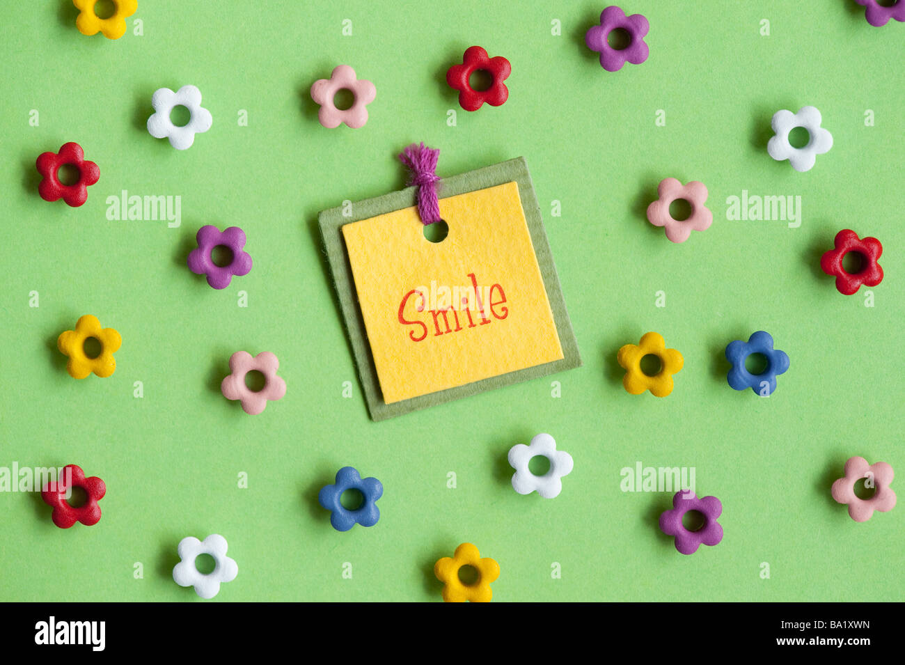 Smile label and flower shapes on green background Stock Photo