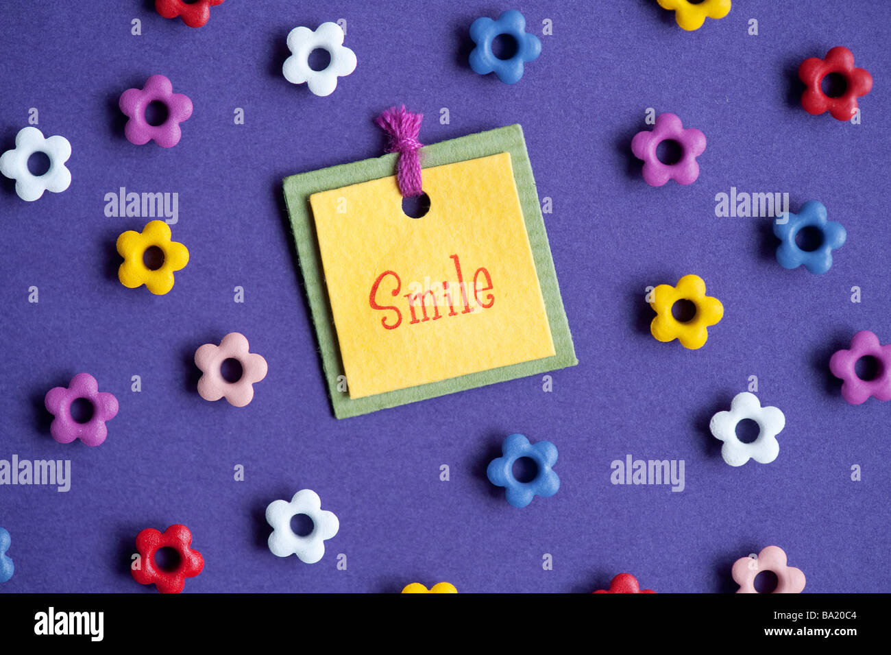 Smile label and flower shapes on purple background Stock Photo