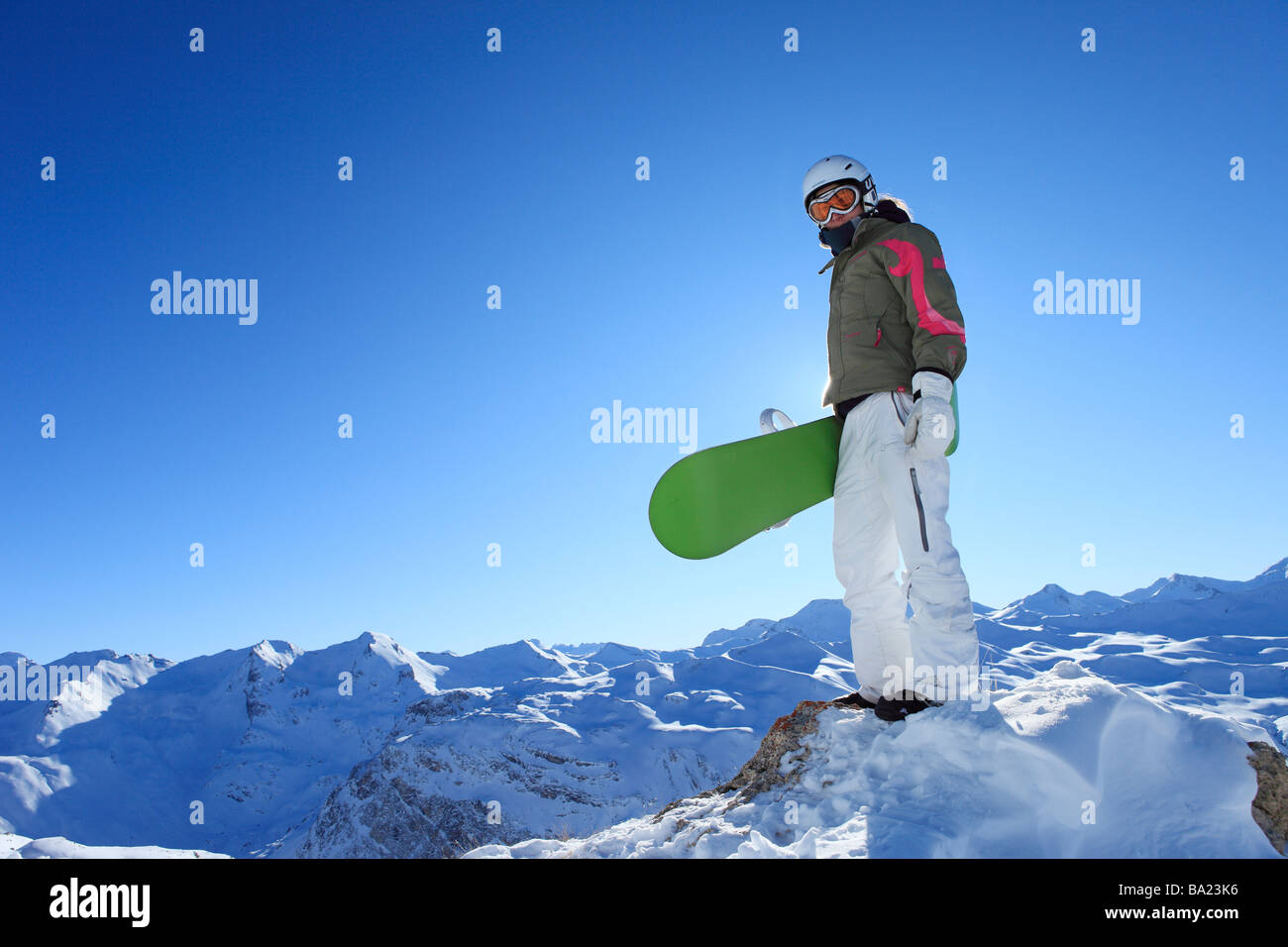 A snowboarder stands proudly on the summit of a mountain in the ski resort of Tignes, Espace Killy, France Stock Photo