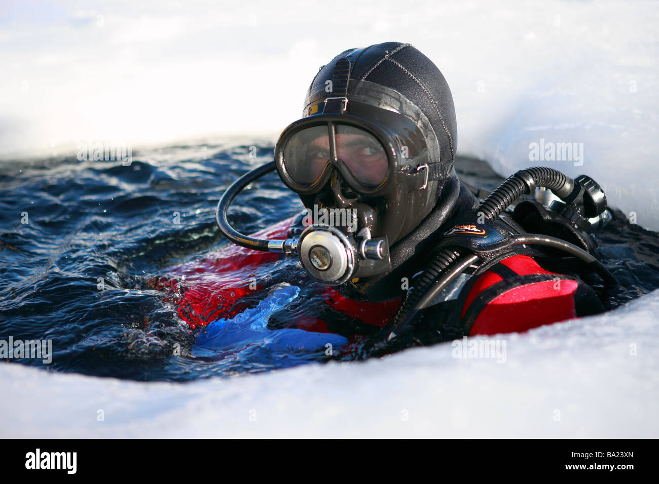 Ice diver diving into frozen lake hires stock photography and images