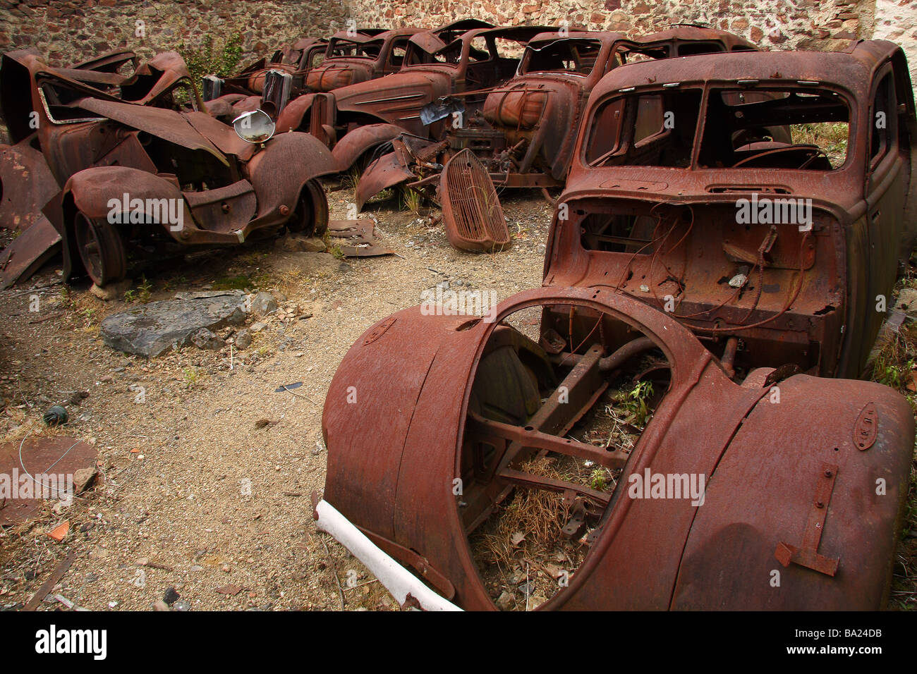The remains of several burnt out old cars in the martyred village of Oradour sur Glane Limousin France Stock Photo