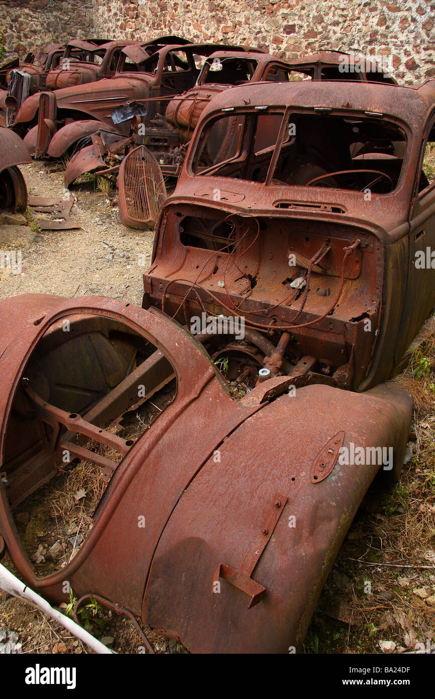 The remains of several burnt out old cars in the martyred village of Oradour sur Glane  France Stock Photo