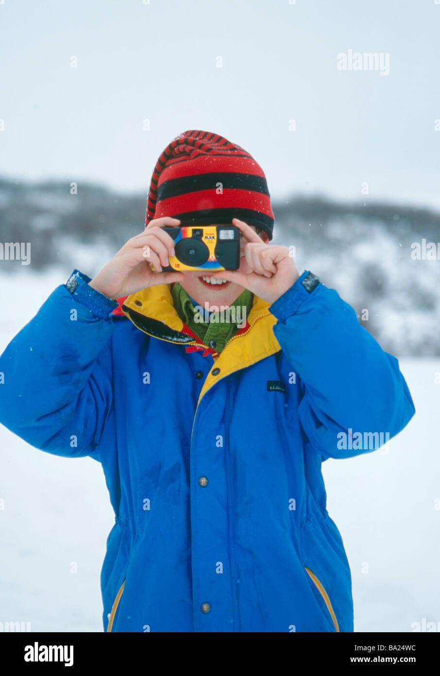 young boy in colorful jacket taking photograph of photographer Stock Photo