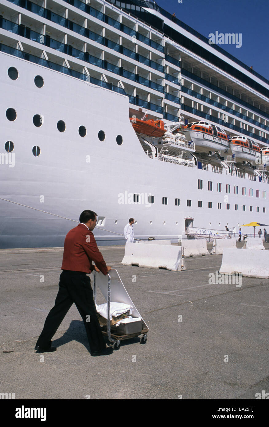 crew member with cart outside Costa Mediterranea cruise ship docked in the port of Savona Stock Photo