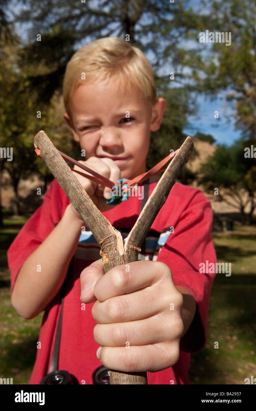 Boy (79) using slingshot Stock Photo Alamy