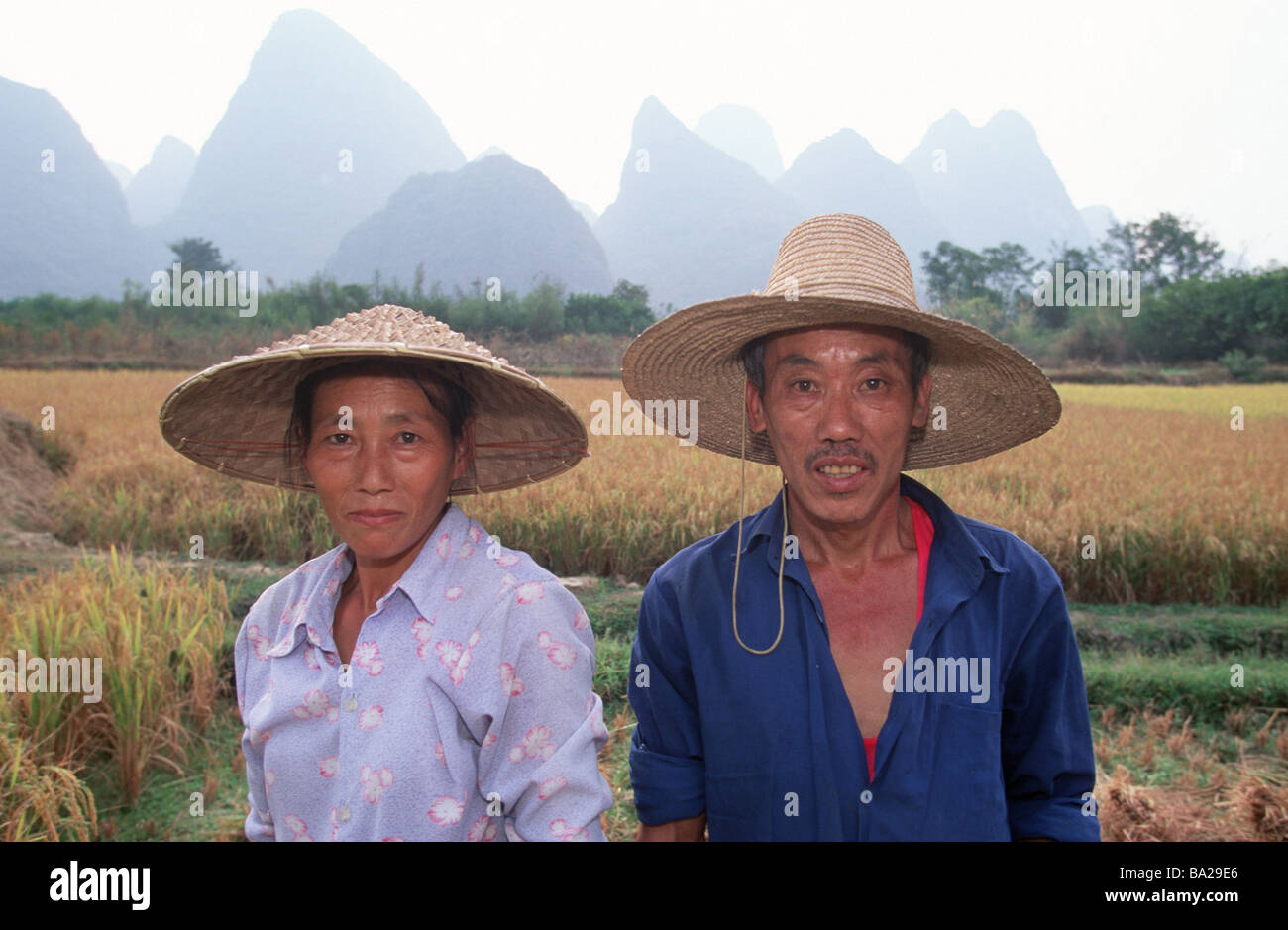 China Guangxi Yangshuo paddy pair straw hats gaze camera semi-portrait series Asia Eastern Asia natives rice-farmers couple Stock Photo