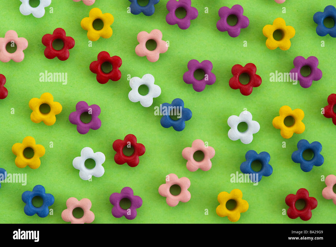 Multicoloured craft flower shapes on green background Stock Photo
