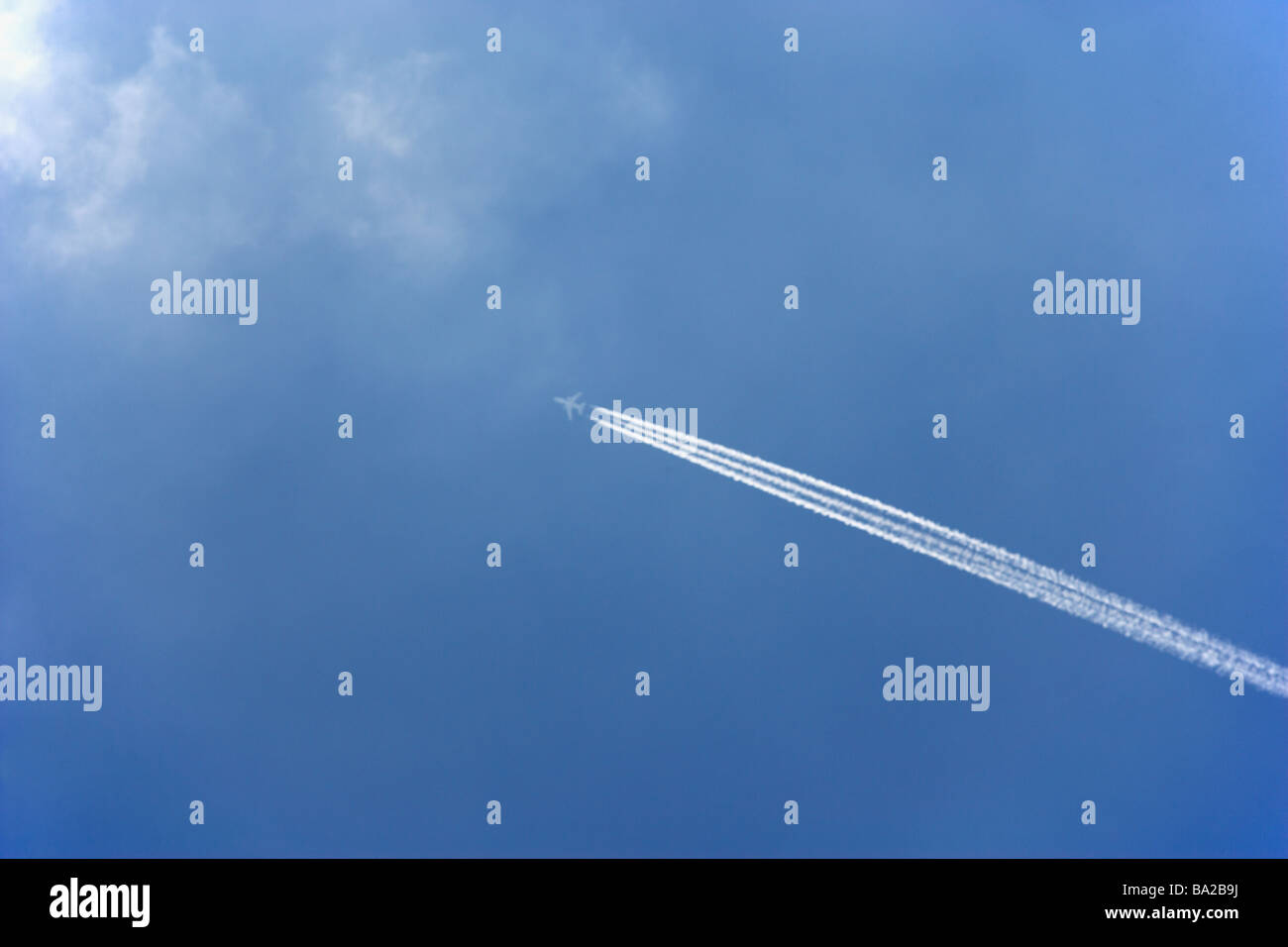 White Condensation Trail From A Commercial Airplane As It Flies Across A Blue Sky Stock Photo