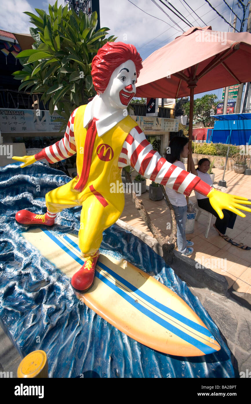 Indonesia, Bali. Kuta. Surfers, McDonalds restaurant, surfing Ronald McDonald statue. Stock Photo