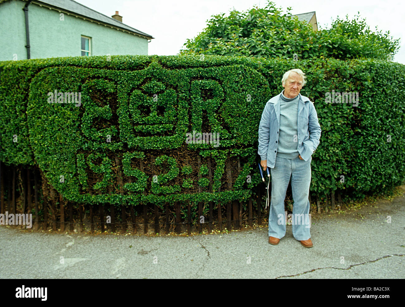 1977 Silver Jubilee hedge trimmer/topiary in suburbia Stock Photo