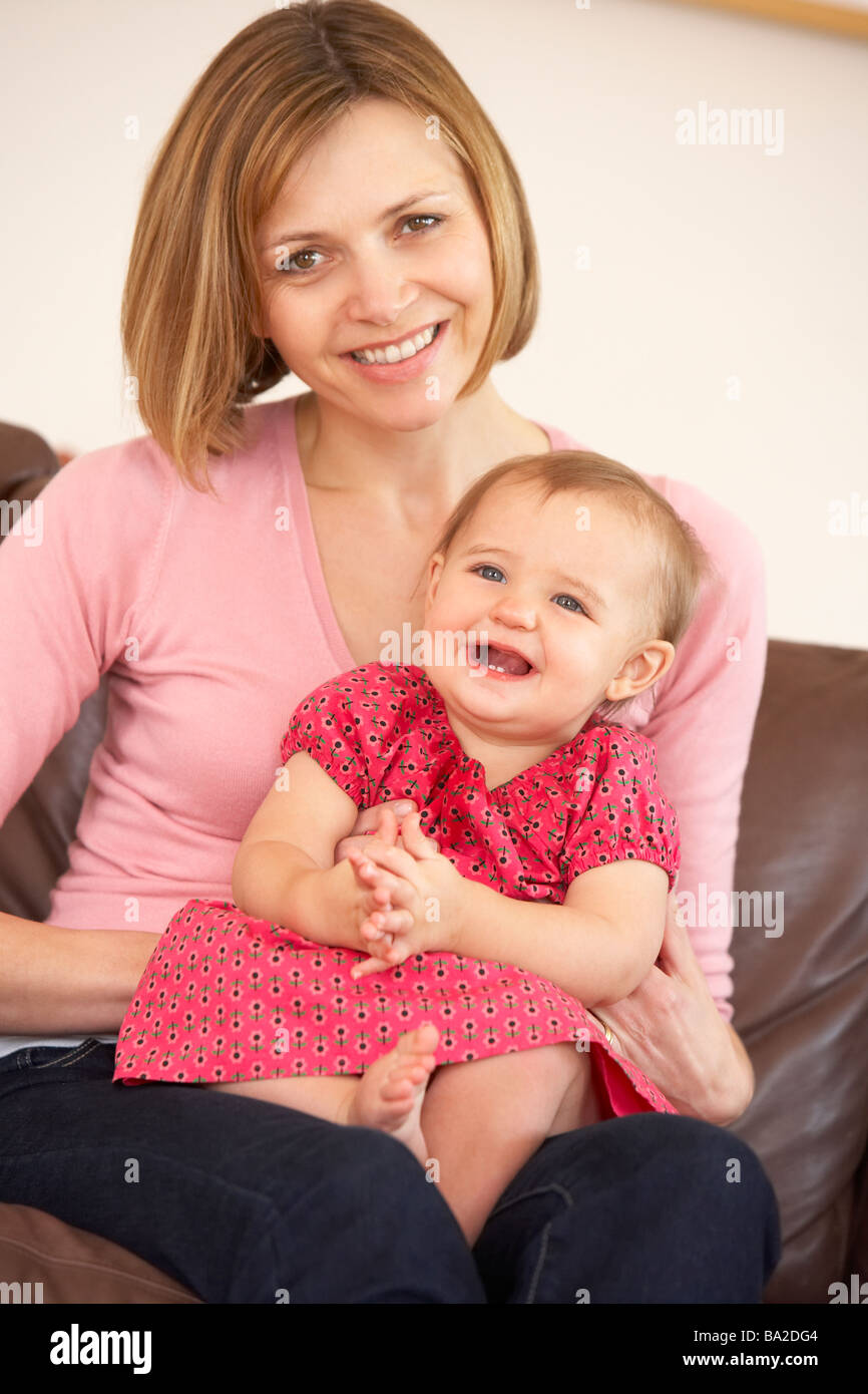 Mother And Baby Daughter On Sofa Stock Photo