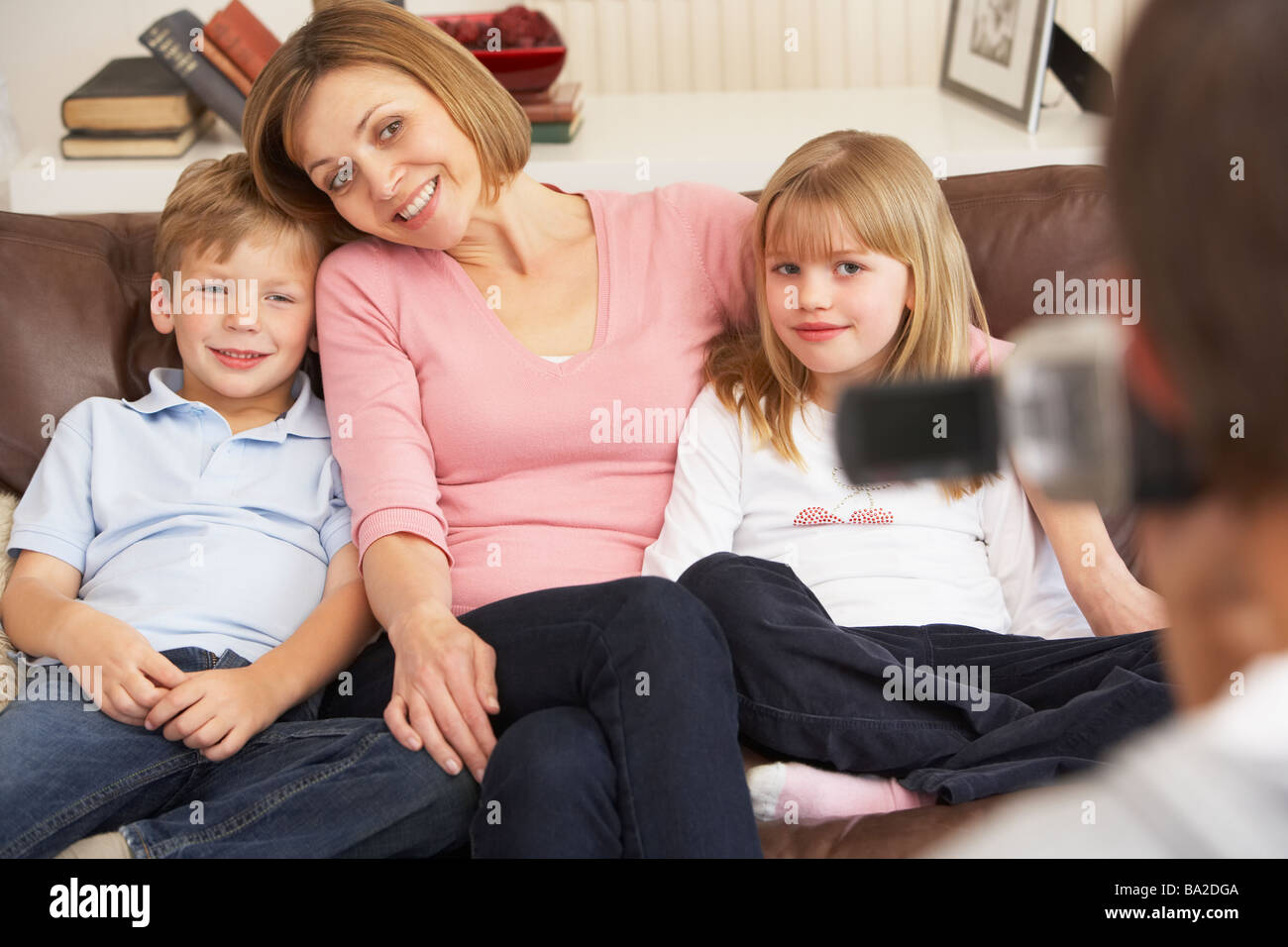 Mother And Children On Sofa Being Filmed On Video Camera Stock Photo