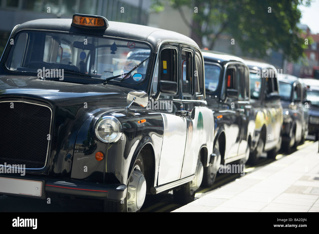 London Taxis Lined Up On Sidewalk Stock Photo