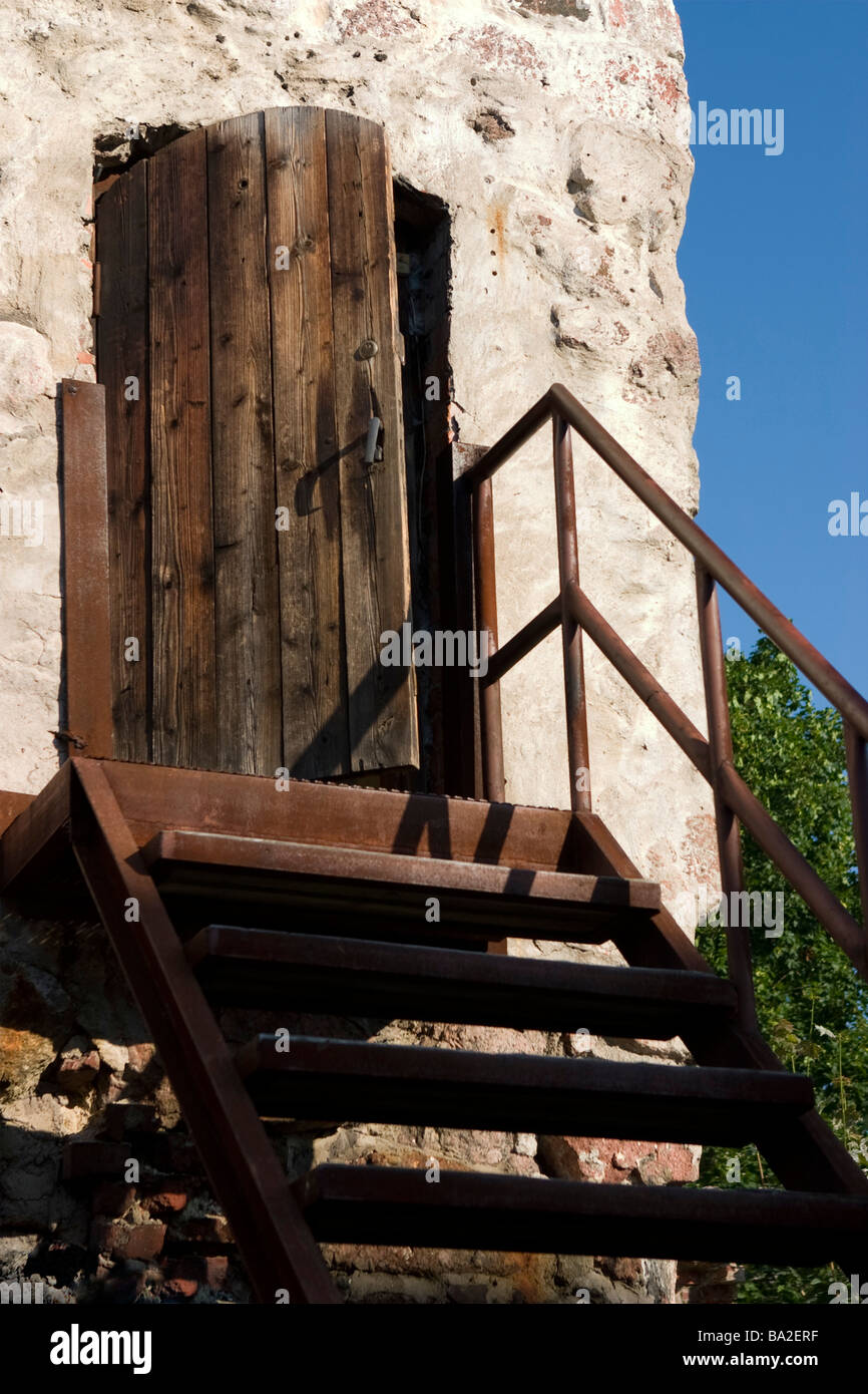 Metal stairway leading to old wooden door. Stock Photo