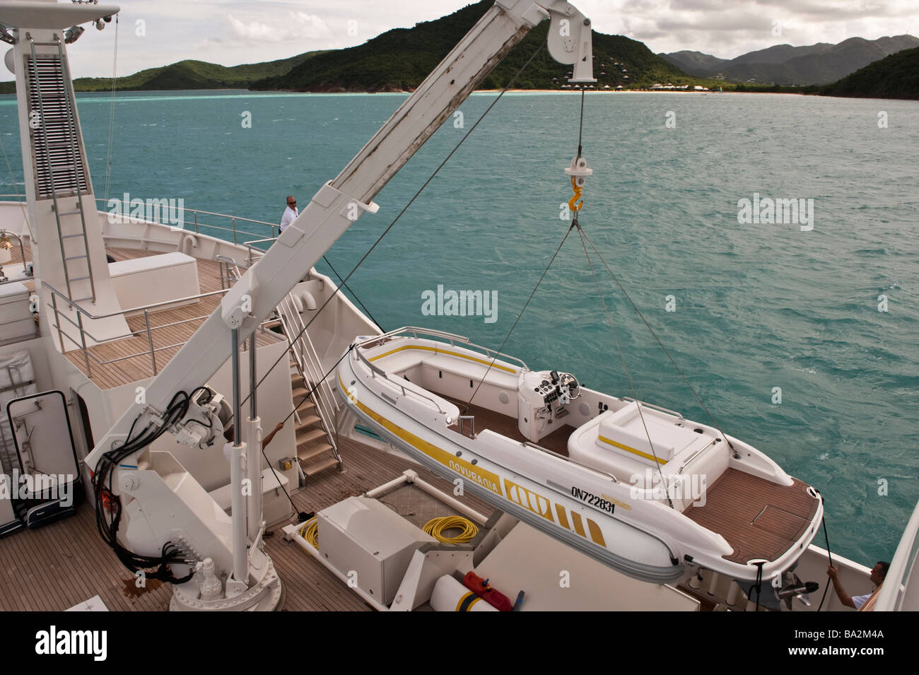 Aboard yacht 'Big Aron' beginning to crane the tender on the foredeck into the water Stock Photo