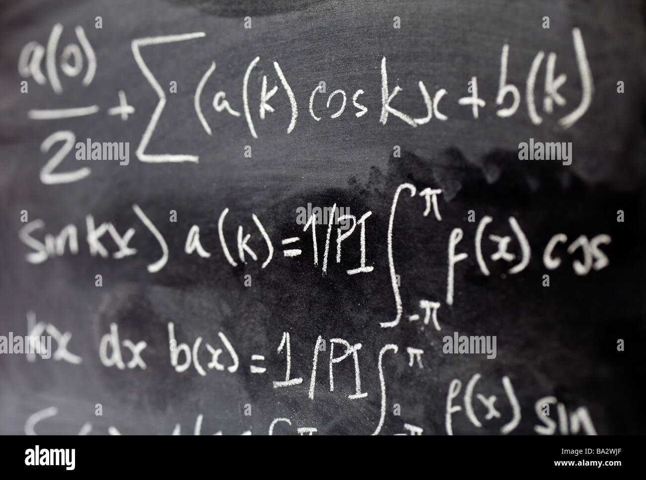 Mathematical equations written on a blackboard in a classroom close up Stock Photo