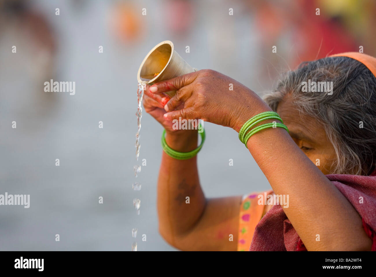 Woman carrying out puja (hindu devotion) by the river Ganges at Kumh Mela festival, Allahabad, India Stock Photo