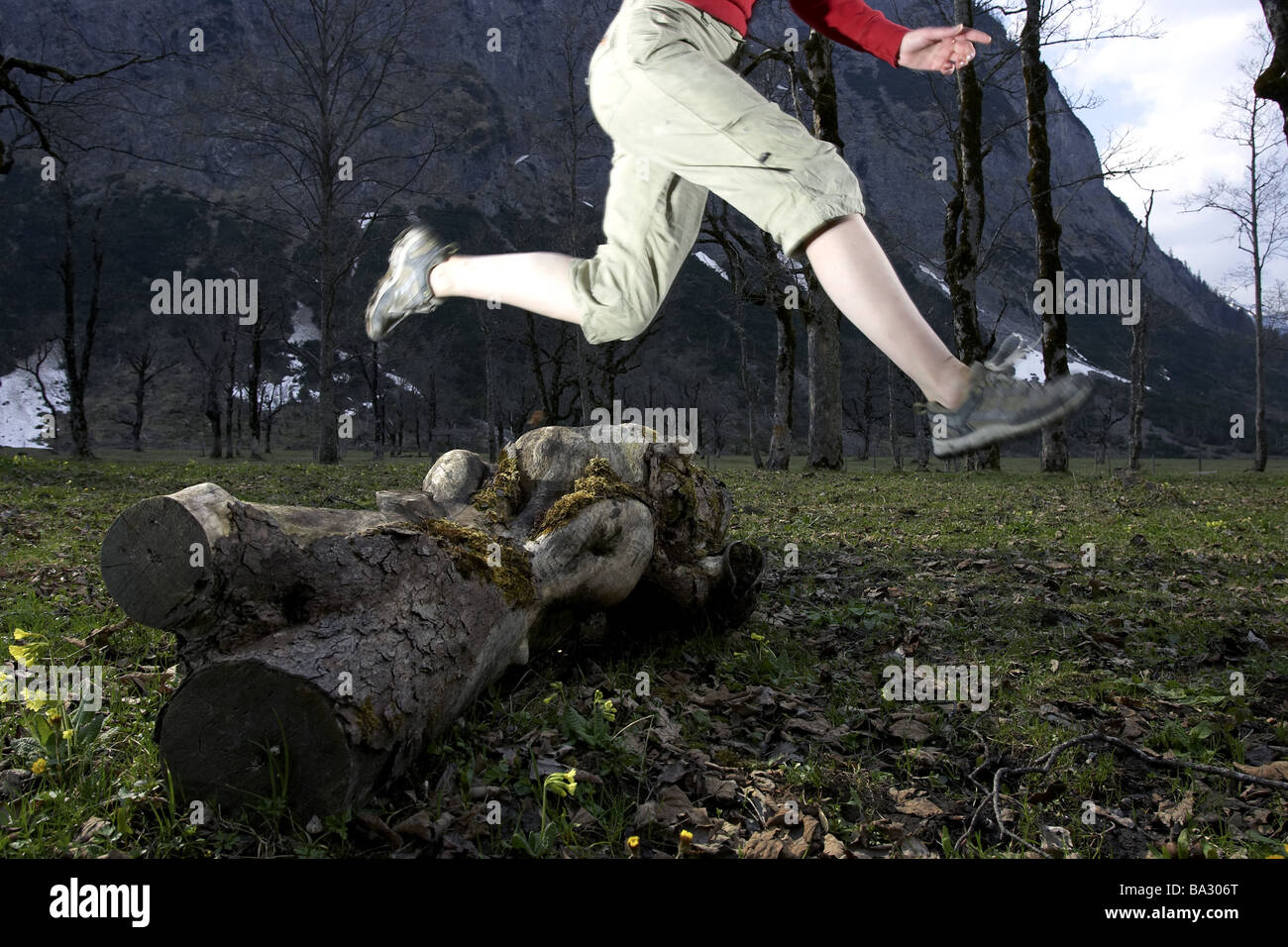 Woman young runs detail legs jump log at the side forest series people 20-30 years leisurewear athletically movement runs Stock Photo