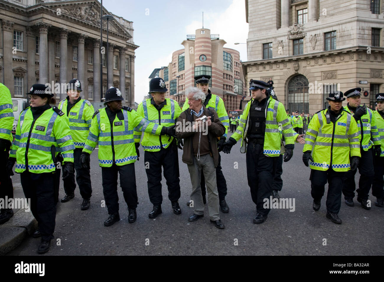 Police move along a protester at the Bank of England during G20 protest Stock Photo