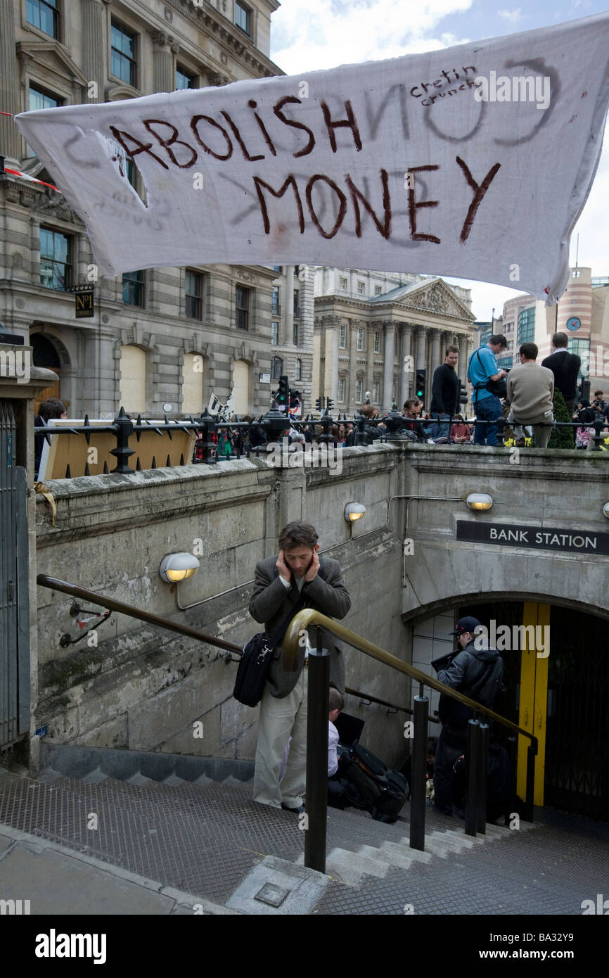 A sign reading 'Abolish Money' hangs across the entrance to Bank Underground station during G20 protests at Bank of England, Lon Stock Photo
