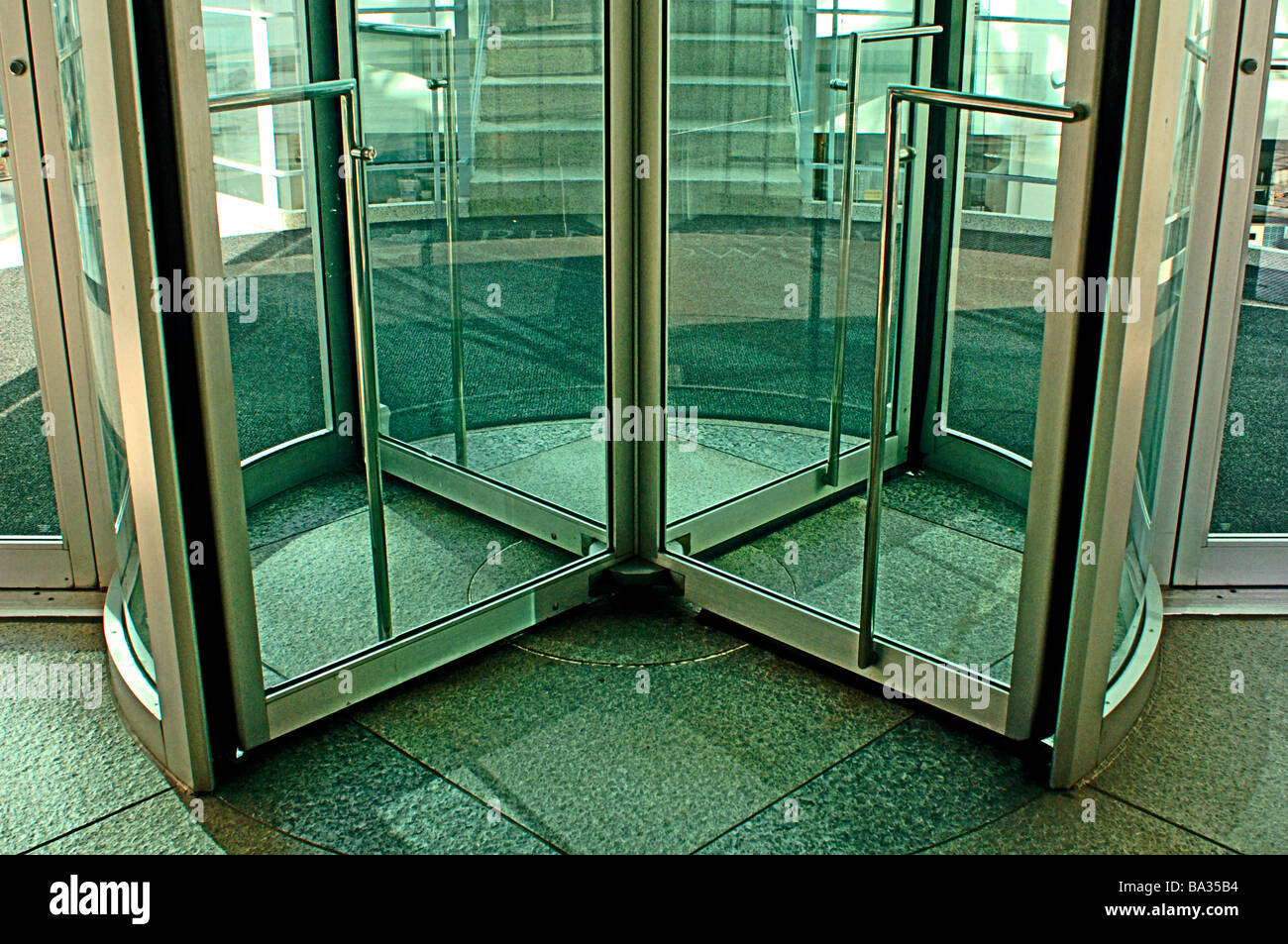 Revolving glass door into a modern commercial building Stock Photo