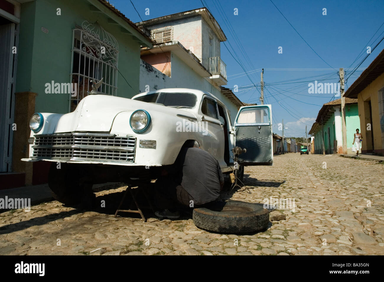 CUBA Trindad An American 1950 s car being mended by it s owner in the street March 2009 Stock Photo