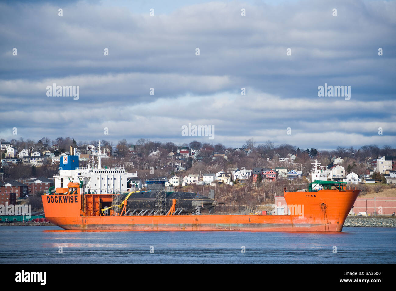 A semi-submersible ship embarks the submarine HMCS CHICOUTIMI in Halifax Harbour. Stock Photo