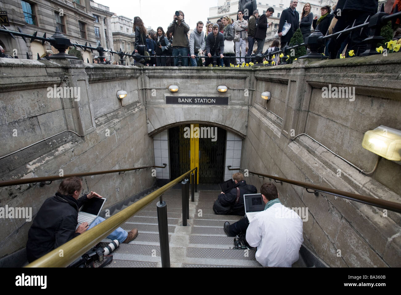 Photographers and journalists sit on steps at Bank underground station to transmit media from the G20 protest at Bank of England Stock Photo